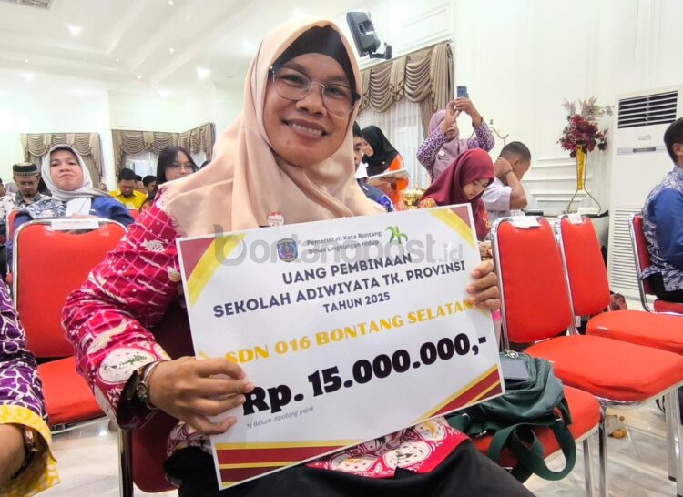 Saat Kepala Sekolah SDN 016 Bontang Selatan, Tri Ayuningsih Pujiastuti, menunjukan penghargaan Sekolah Adiwiyata Tingkat Provinsi Kaltim. (Dwi Kurniawan Nugroho/Bontang Post)