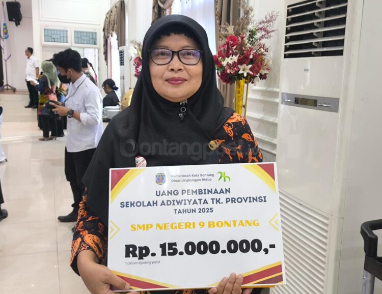 Kepala SDN 016 Bontang Selatan, Lilyn Indriyawati saat menunjukkan penghargaan Sekolah Adiwiyata Tingkat Provinsi Kaltim kepada awak media. (Dwi Kurniawan Nugroho/Bontang Post)