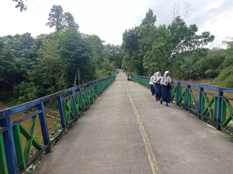 Kondisi jembatan akses menuju SMPN 5 Bontang tampak miring dan berlubang, menjadi satu-satunya jalur masuk siswa sebelum mencapai bangunan sekolah utama.