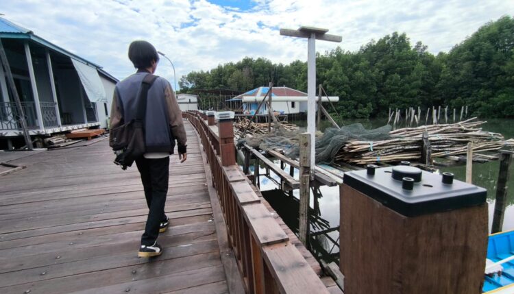 Lampu hias pada fasilitas jembatan kayu di Gang Keluarga 1, Kelurahan Gunung Elai, terlihat lepas meski jembatan belum diresmikan. (Nasrullah/Bontang Post)