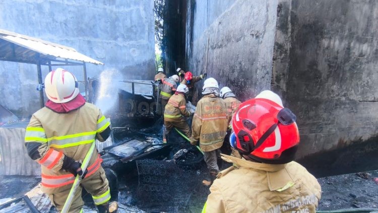 Petugas Damkar Bontang berjibaku memadamkan kebakaran di area penumpukan barang bekas belakang eks Futsal Maharani, Tanjung Laut, Sabtu (28/3/2026). Api diduga berasal dari aktivitas bakar sampah.