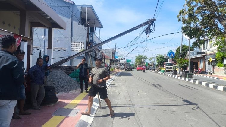 Kondisi tiang listrik kayu yang rebah beserta kabel di Jalan WR Supratman, Tanjung Laut, menunggu penanganan. (Dwi Kurniawan Nugroho / Bontang Post)