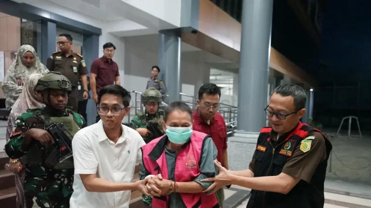Tersangka AS, mantan Kepala Dinas Pertambangan dan Energi Kukar, saat digiring petugas menuju mobil tahanan di Gedung Kejati Kaltim, Samarinda. AS ditahan selama 20 hari ke depan di Rutan Samarinda untuk kepentingan penyidikan lebih lanjut. (KP)