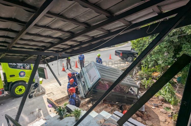 Mobil Kijang kapsul berwarna hijau yang terperosok di sebelah Barbershop Confidante di Jalan Simon Tampubolon (HOP).