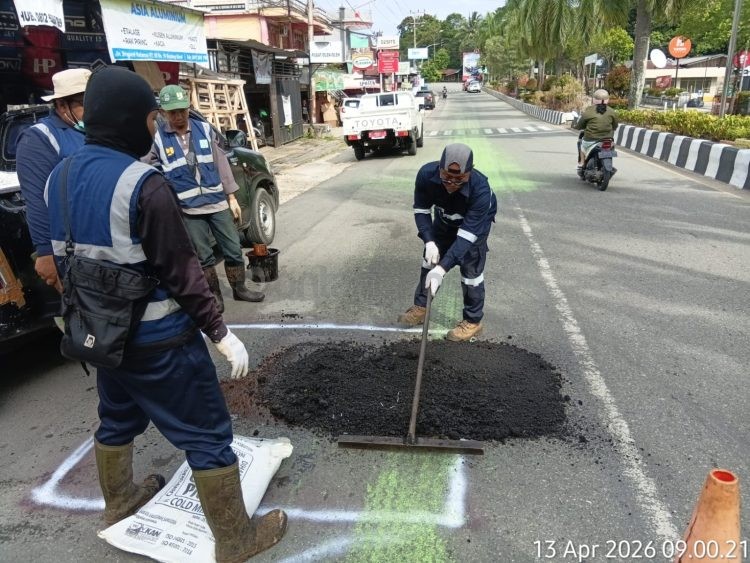 Petugas melakukan penambalan pada jalan amblas di Jalan Brigjen Katamso yang sebelumnya ditandai warga demi mengurangi risiko kecelakaan.