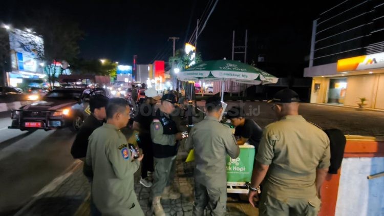 Petugas Satpol PP Bontang mengarahkan pedagang untuk tidak berjualan di atas trotoar saat penertiban di jalan protokol. (Dwi Kurniawan Nugroho/ Bontang Post)