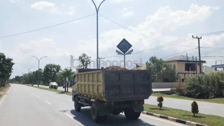 Truk pengangkut material tanah melintas tanpa penutup terpal di Jalan A. Wahab Syahranie, Sangatta Utara, Kutim, Senin (20/4). (JUFRIADI/KP)