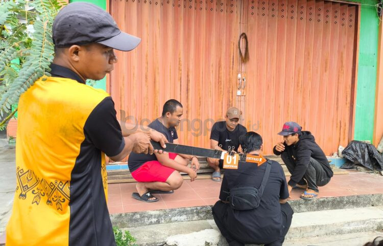 MT (pakai topi, kanan) saat menjalani prarekonstruksi kasus meninggalnya Ri usai insiden pencurian mangga di Kelurahan Api-Api. (Nasrullah/ Bontang Post)