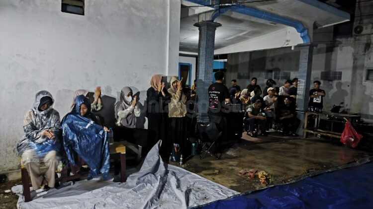 Warga tetap bertahan menyaksikan nobar film dokumenter Pesta Babi di Sekretariat FJB Bontang meski hujan mengguyur lokasi acara. (Dwi Kurniawan Nugroho/Bontang Post)