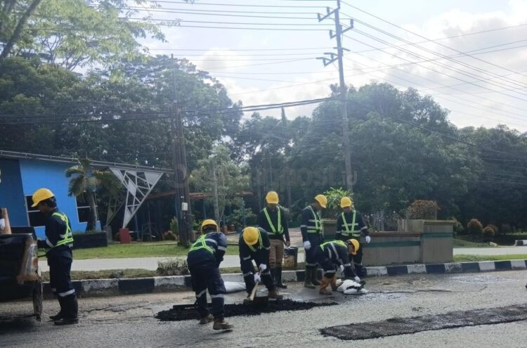 Petugas PUPRK Bontang melakukan tambal sulam menggunakan aspal dingin di ruas jalan nasional depan RSUD Taman Husada sebagai penanganan sementara sambil menunggu perbaikan permanen dari pemerintah pusat.