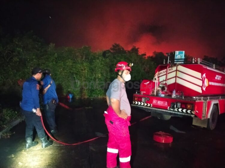 Tim Disdamkartan Bontang membantu memadamkan kebakaran hutan dan lahan (karhutla) di sekitar kawasan objek vital nasional (Obvitnas) di Jalan Soekarno-Hatta. (Dwi Kurniawan Nugroho/Bontang Post)