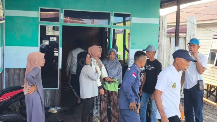 Istri Jainuddin, Mardianah, dibantu keluarga saat hendak menuju pemakaman Bontang Kuala setelah mendapat kabar suaminya ditemukan meninggal dunia. (Dwi Kurniawan Nugroho/Bontang Post)