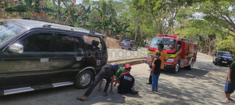 Regu Alpha Pos Bontang Lestari saat mengevakuasi mobil yang menabrak trotoar di Jalan Karya Bakti RT 03, Kelurahan Bontang Lestari.