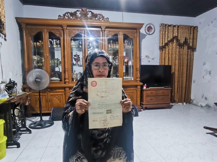 Siti Rabiah menunjukkan surat pernyataan penggarapan/penguasaan tanah yang menjadi dasar klaim kepemilikan lahan di akses Jalan Gotong Royong, Bontang Barat. (Dwi Kurniawan Nugroho/Bontang Post)