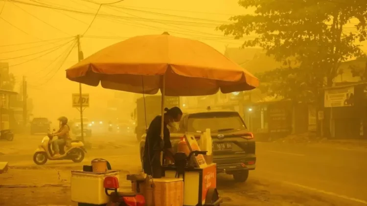 Pedagang kaki lima tetap berjualan di tengah kabut asap karhutla yang menyelimuti Palangka Raya, saat kualitas udara tercatat berbahaya. (Sumber: Threads/@a_rizaldi)